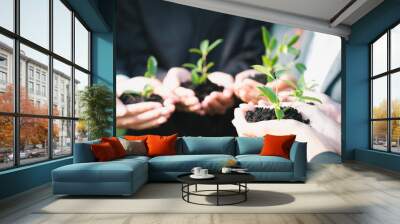 Business people hold plant together in unity and teamwork concept of eco company committed to corporate social responsible, reducing CO2 emission, embrace ESG principle for sustainable future. Gyre Wall mural