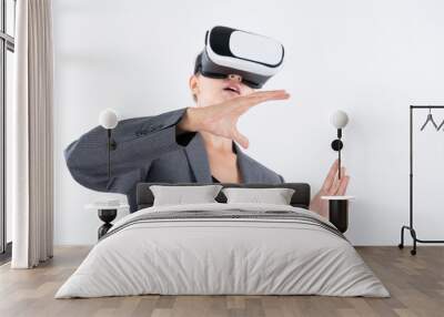 Business woman holding something while wearing VR goggle and standing at white background. Project manager with headset enter visual reality world program by using technology innovation. Contraption. Wall mural