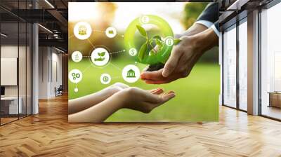 Businessman and little kid holding seedling plant together with ESG and eco icon. Green business investing on environment sustainability to provide greener future for next generation. Panorama Wall mural