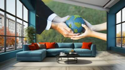 Businessman hand giving Earth globe to little boy as Earth day concept as corporate social responsible to contribute greener environmental protection for sustainable future generation. Gyre Wall mural