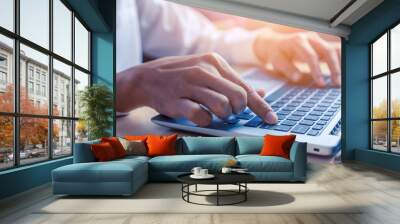 Businessman hand typing on computer keyboard of a laptop computer in office. Business and finance concept. Wall mural