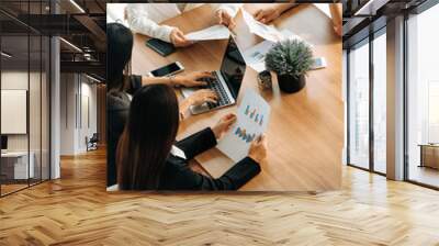 Businesswoman in group meeting discussion with other businesswomen colleagues in modern workplace office with laptop computer and documents on table. People corporate business work team concept. uds Wall mural