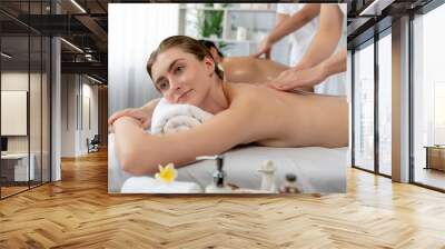 Caucasian couple customer enjoying relaxing anti-stress spa massage and pampering with beauty skin recreation leisure in day light ambient salon spa at luxury resort or hotel. Quiescent Wall mural