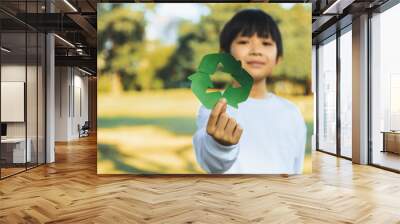 Cheerful young asian boy holding recycle symbol on daylight natural green park promoting waste recycle, reduce, and reuse encouragement for eco sustainable awareness for future generation. Gyre Wall mural