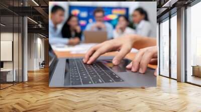 Closeup hand typing keyboard laptop with blurred background of business people using laptop to analyze financial data or data analysis display on screen background. Meticulous Wall mural