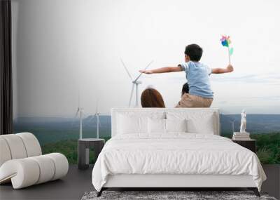 Concept of progressive happy family enjoying their time at the wind turbine farm. Electric generator from wind by wind turbine generator on the country side with hill and mountain on the horizon. Wall mural