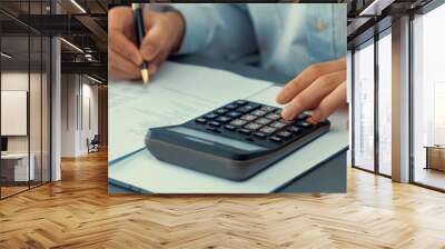 Corporate auditor calculating budget with calculator on his office desk. Dedicated accountant professional of accounting business company analyzing financial document to forecast income. Insight Wall mural