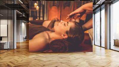 Couple customer enjoying relaxing anti-stress head massage and pampering facial beauty skin recreation leisure in warm candle lighting ambient salon spa in luxury resort or hotel. Quiescent Wall mural