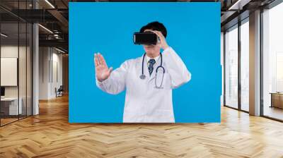 Doctor with stethoscope using VR headset pointing selection 3D hologram healthcare application against blue background with medical technology innovation poster banner materials design. Contrivance. Wall mural