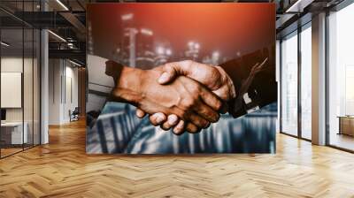 Double exposure image of business people handshake on city office building in background showing partnership success of business deal. Concept of corporate teamwork, trust partner and work agreement. Wall mural