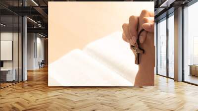 Female folded hand prayed on holy bible book faithfully at wooden church. Concept of hope, religion, faith, christianity, catholic, believe and god blessing. Warm and brown background. Burgeoning. Wall mural