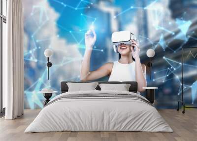 Female stand wear white VR headset and white sleeveless connect metaverse, future technology create cyberspace community. She use index finger touch hologram object of virtual reality. Hallucination. Wall mural