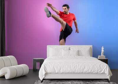 Full body length gaiety shot athletic and sporty young man with fitness in cardio exercise, kicking position posture on isolated background. Healthy active and body care lifestyle. Wall mural