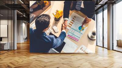 Group business people handshake at meeting table in office together with confident shot from top view . Young businessman and businesswoman workers express agreement of investment deal. Wall mural