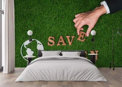 Hand arrange wooden alphabet in ecological awareness campaign with ECO icon design on biophilia green grass background to promote environmental protection for greener and sustainable future. Gyre Wall mural