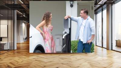 Happy and lovely couple with eco-friendly conscious recharging electric vehicle from EV home charging station. EV car technology utilized for residential home to future sustainability. Synchronos Wall mural