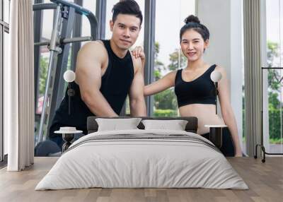 Healthy man and woman doing weight training in gym fitness center. Bodybuilding concept. Wall mural