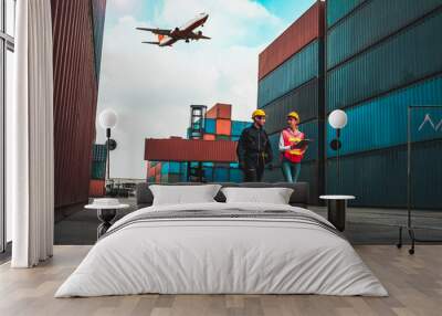 Industrial worker works with co-worker at overseas shipping container port . Logistics supply chain management and international goods export concept . Wall mural