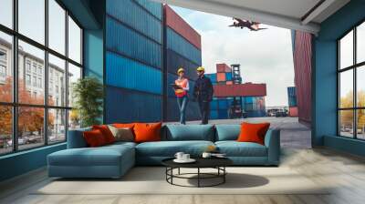 Industrial worker works with co-worker at overseas shipping container port . Logistics supply chain management and international goods export concept . Wall mural