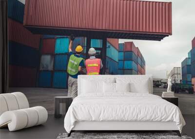 Industrial worker works with co-worker at overseas shipping container yard . Logistics supply chain management and international goods export concept . Wall mural