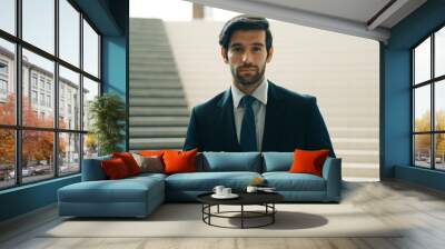 Portrait of Serious business man looking at camera while standing at stairs. Closeup of successful man staring at camera while wearing business suit. Happy executive manager look at camera. Exultant. Wall mural