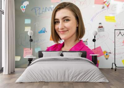 Portrait of young beautiful caucasian businesswoman smiling and posing with confident while looking at camera in front of whiteboard with mind map and colorful sticky notes. Closeup. Immaculate. Wall mural