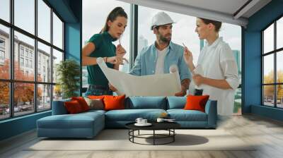 Professional architect engineer team talking, sharing, brainstorming about design while manager hold at project plan. Young architect holding plan while manager listen and point at plan. Tracery Wall mural