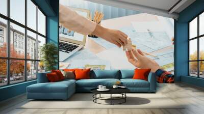 Professional engineer and architect collaborate on eco house project at meeting table with green design blueprint and architectural equipment at modern office. Focus on hand. Close up. Delineation. Wall mural