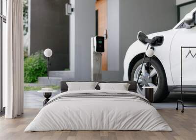 Progressive concept of EV car and home charging station powered by sustainable and clean energy with zero CO2 emission for green environmental. Charging point at residential area for electric vehicle. Wall mural