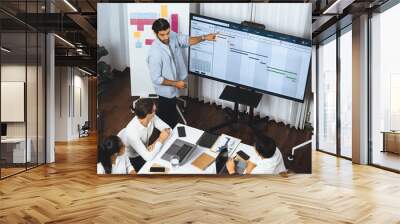 Project manager communicate and collaborate with team using project management software display on monitor, tracking progress of project task and making schedule plan at meeting table. Prudent Wall mural