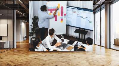 Project manager communicate and collaborate with team using project management software display on monitor, tracking progress of project task and making schedule plan at meeting table. Prudent Wall mural