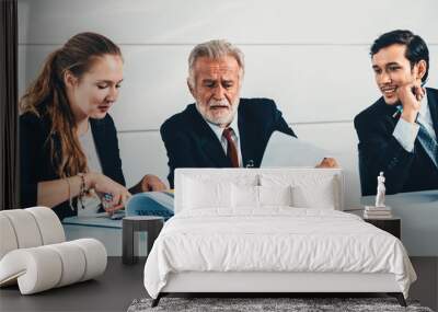 Senior old executive manager working with young businesspeople in office meeting room. Old man is company leader sitting with secretary and translator. International corporate business concept. uds Wall mural