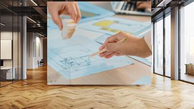 Skilled architect team using architectural equipment during colleague discussion about building design at meeting table with blueprint scatter around. Closeup. Focus on hand. Delineation. Wall mural