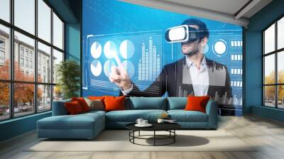 Skilled business man looking data analysis while planning strategy by using visual reality glasses. Professional smart investor checking financial graph holographic while wearing VR goggle. Deviation. Wall mural