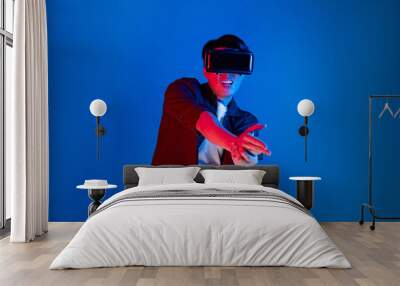 Smart gamer wearing VR turning to metaverse world playing gun shooting hunter isolated blue neon light connected to victory animal hunting futuristic technology hologram virtual reality. Contrivance. Wall mural