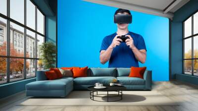 Smart gaming player wearing VR controlling joystick hologram screen monitor isolated blue background screen connecting digital futuristic technology virtual reality in metaverse world. Contrivance. Wall mural