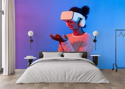 Smiling African woman wearing VR smelling good through metaverse flowers filed world and butterfly insect bug hologram vibrant neon pink blue lighting background technology 3D cyberspace. Contrivance. Wall mural