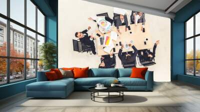 Successful business people celebrate together with joy at office table shot from top view . Young businessman and businesswoman workers express cheerful victory showing success by teamwork . Wall mural