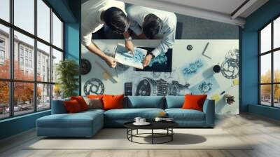 Top down aerial view of manager sitting while answer question about jet engine. Professional engineer looking at turbine engine or electronic generator while colleague asking question. Alimentation. Wall mural