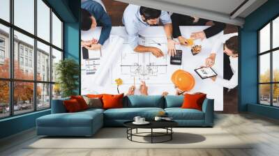 Top view banner of diverse group of civil engineer and client working together on architectural project, reviewing construction plan and building blueprint at meeting table. Prudent Wall mural