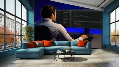 Working smart IT developer analyzing data software development on two pc screen, creating application program updated version online website page system online at neon light cyber office. Surmise. Wall mural