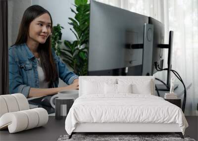 Young Asian in IT developer creating with typing online information on pc with coding program data of website application, wearing jeans shirt. surrounded by safety analysis two screens. Stratagem. Wall mural