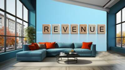 Revenue word wooden block stand on light blue background for earning and profit purpose. Wall mural