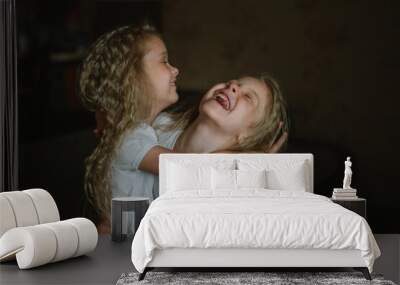 two little girls with curly long hair fooling around at home Wall mural