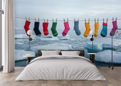 At the North Pole, between two ice floes, four rows of string stretched out with colorful sock-like tights hanging and clipped with clothespins.   Wall mural