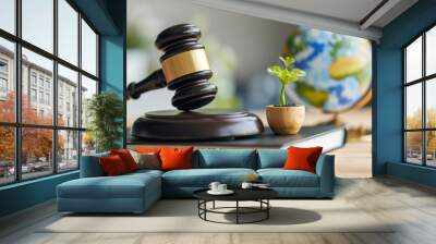 A gavel rests on a book beside a globe and plants, symbolizing environmental law and global justice concepts. Wall mural