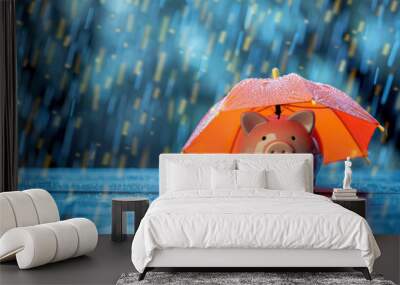 Piggy bank under an orange umbrella in the rain, symbolizing financial protection and saving during difficult times. Wall mural