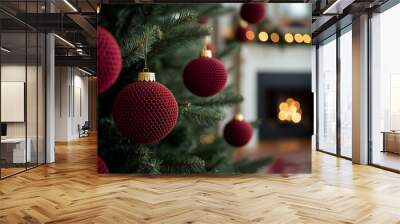 Christmas tree with red decorations against a blurred fireplace in a cozy and modern  living room, in a close up view. Wall mural