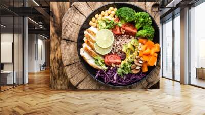 Buddha bowl salad with chicken fillet, brown rice, avocado, pepper, tomato, broccoli, red cabbage, chickpea, fresh lettuce salad, pine nuts and walnuts. healthy food. balanced diet eating. Top view Wall mural