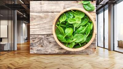 Fresh baby spinach leaves in bowl on wooden background Wall mural